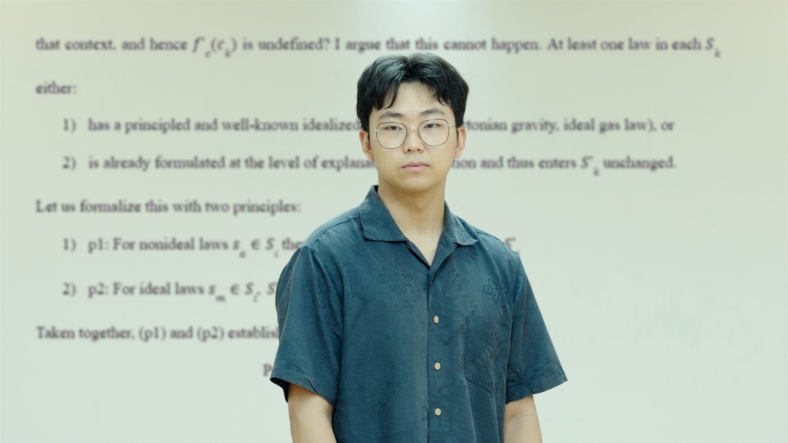 Hong Joo Ryoo standing in front of a projected page of his philosophy paper